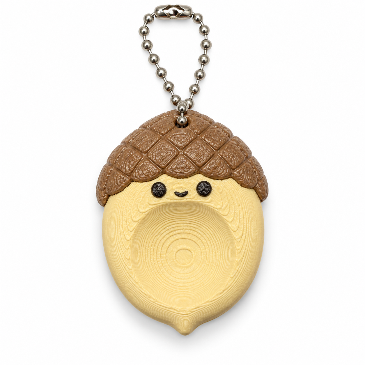 Worry Stone Ghianda AIRA beige e marrone, con incavo per il pollice, cappello a rilievi e catenella argentata su sfondo bianco.