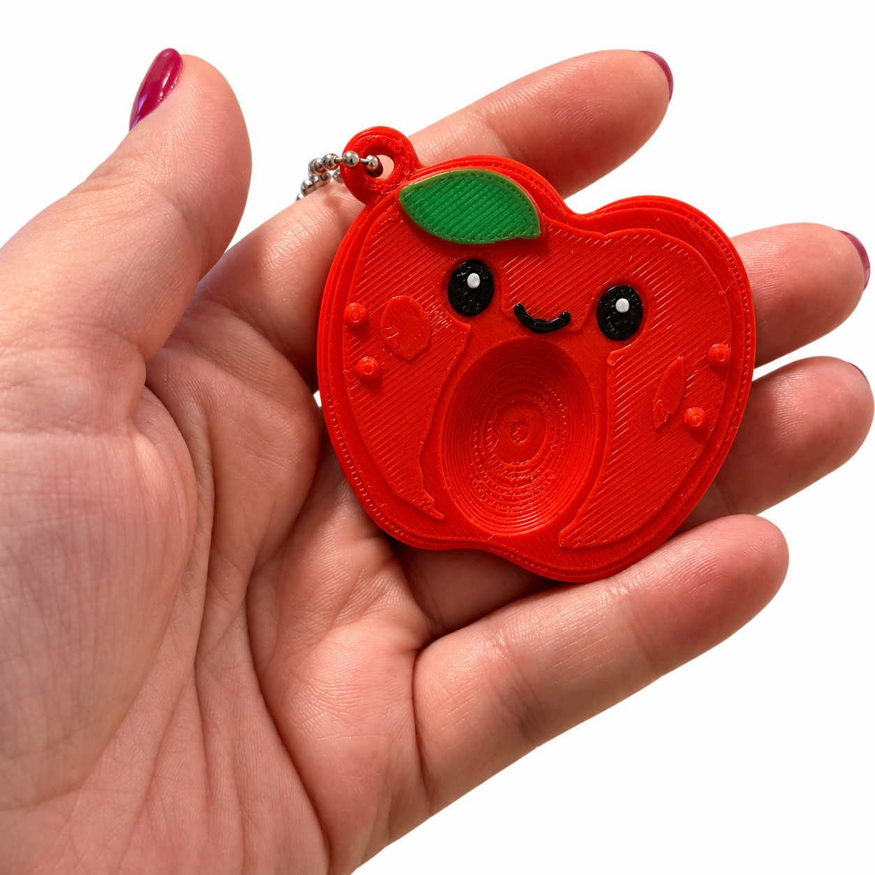Scopri la Worry Stone Mela AIRA: incavo per il pollice e rilievi da esplorare. Fidget sensoriale silenzioso con catenella e design originale.